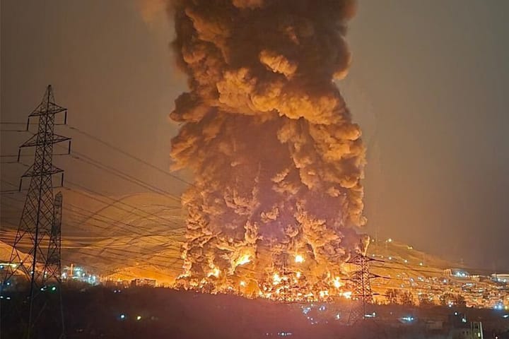 Oil fire smoke and fire looming over mountains in northern Tehran.